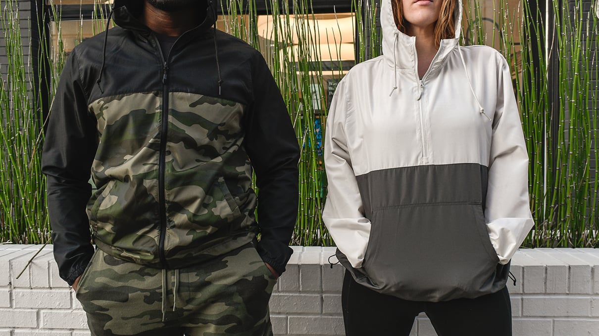 Man and woman wearing full zip windbreaker and hoodie in camo