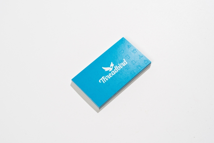 Front of the blue Threadbird business card