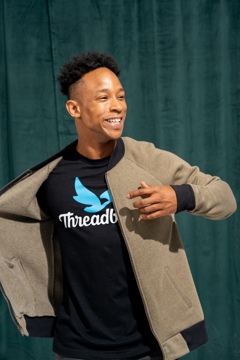 Man wearing a Threadbird printed t-shirt and a Next Level jersey bomber over 