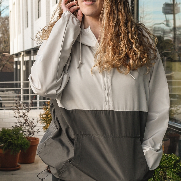 Woman wearing half zip grey and light grey windbreaker 