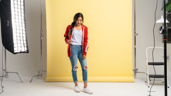 Woman wearing a red jacket modeling on set of a photoshoot 